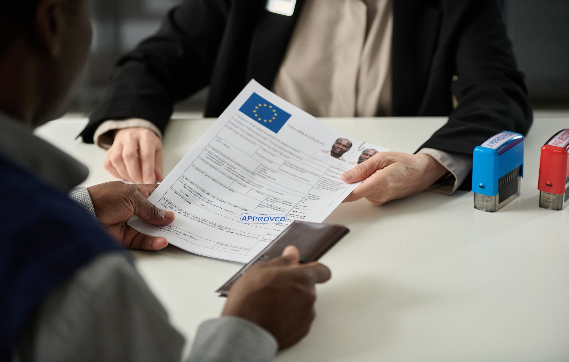 close-up-of-consulate-worker-handing-approved-visa-2022-12-07-01-13-40-utc